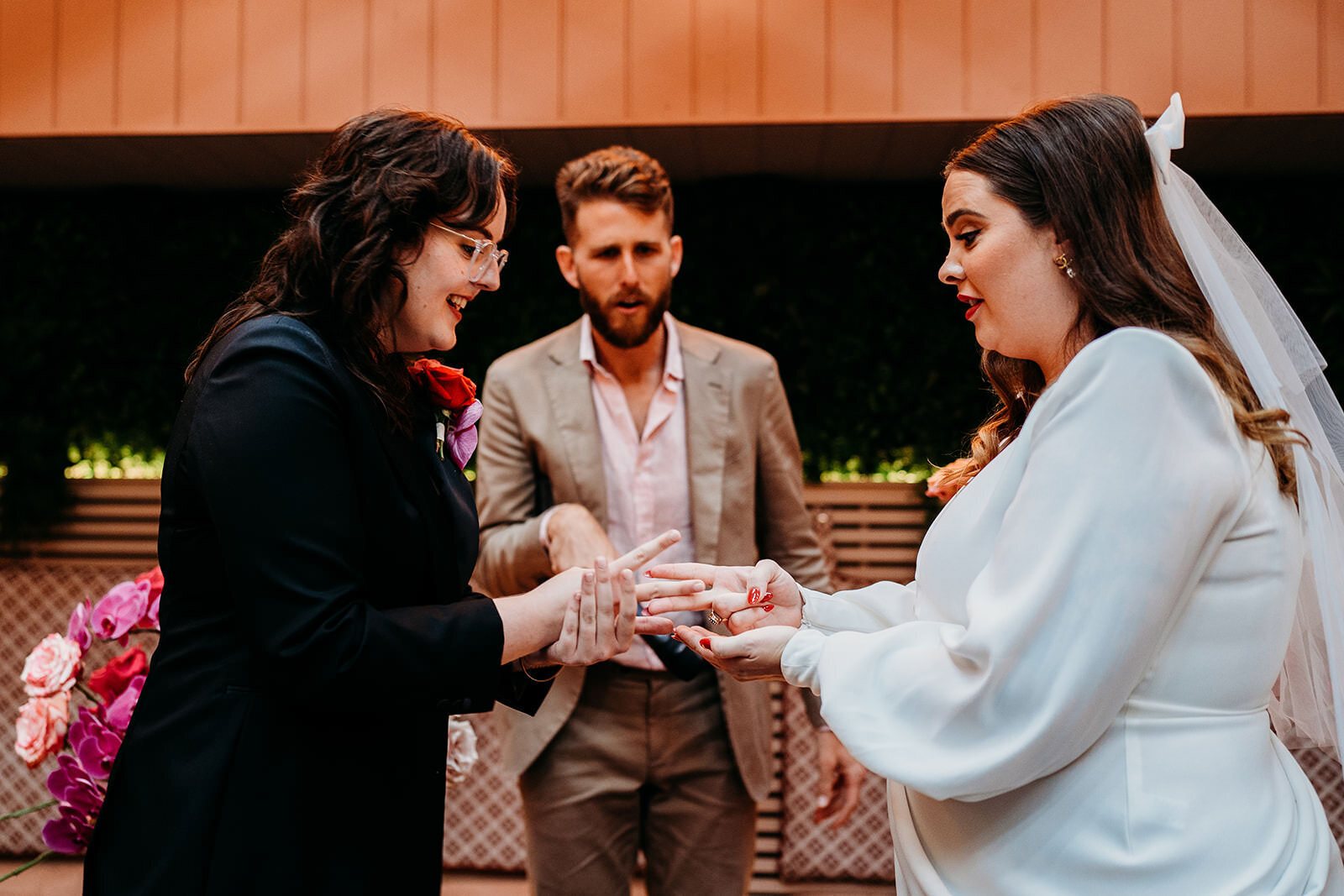 Two brides exchanging rings in front of their celebrant